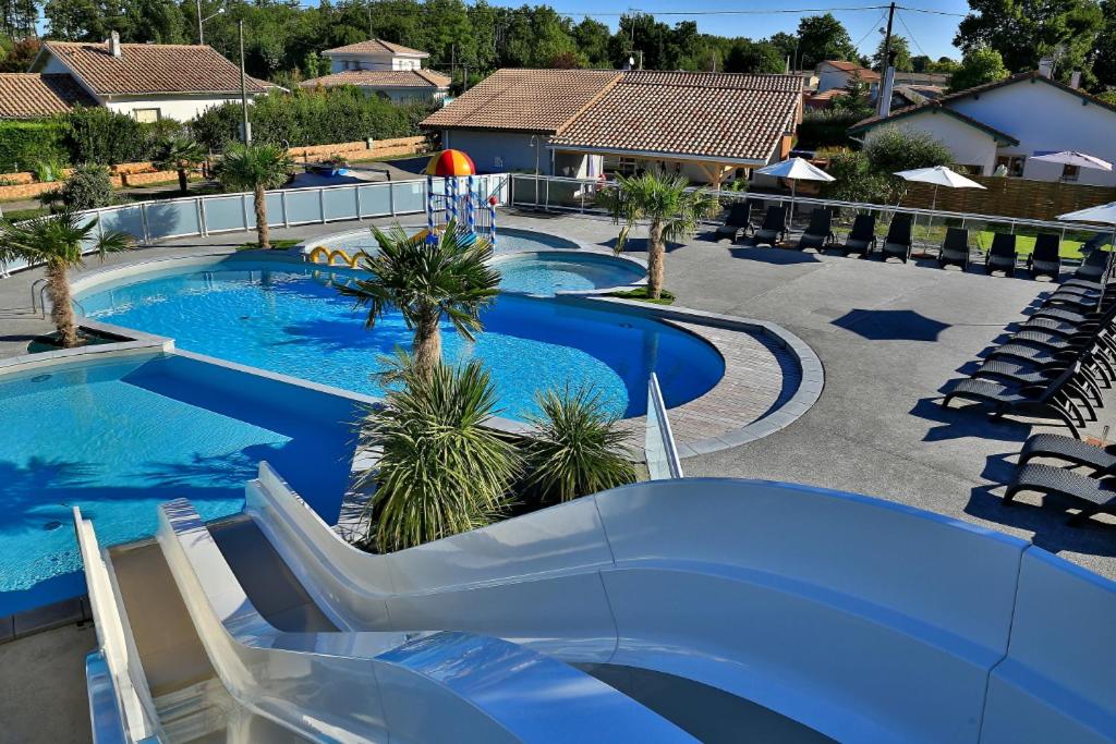 una grande piscina con scivolo in un resort di Domaine Les Abberts ad Arès