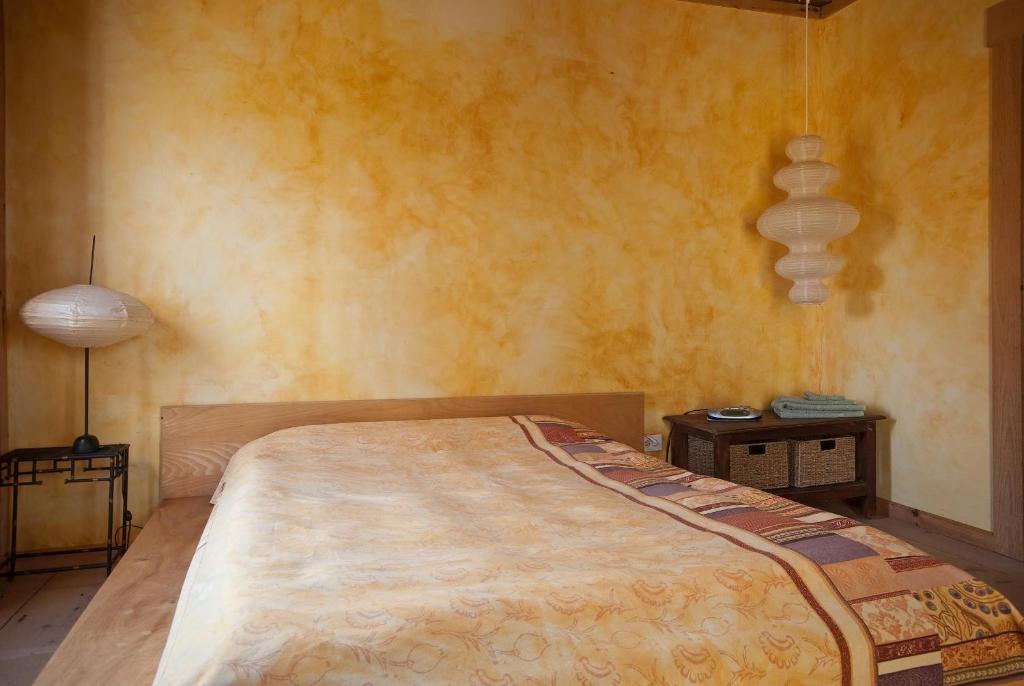 a bedroom with a bed and a table with a lamp at Green Dragon Organic Farm and B&B in Tatamagouche