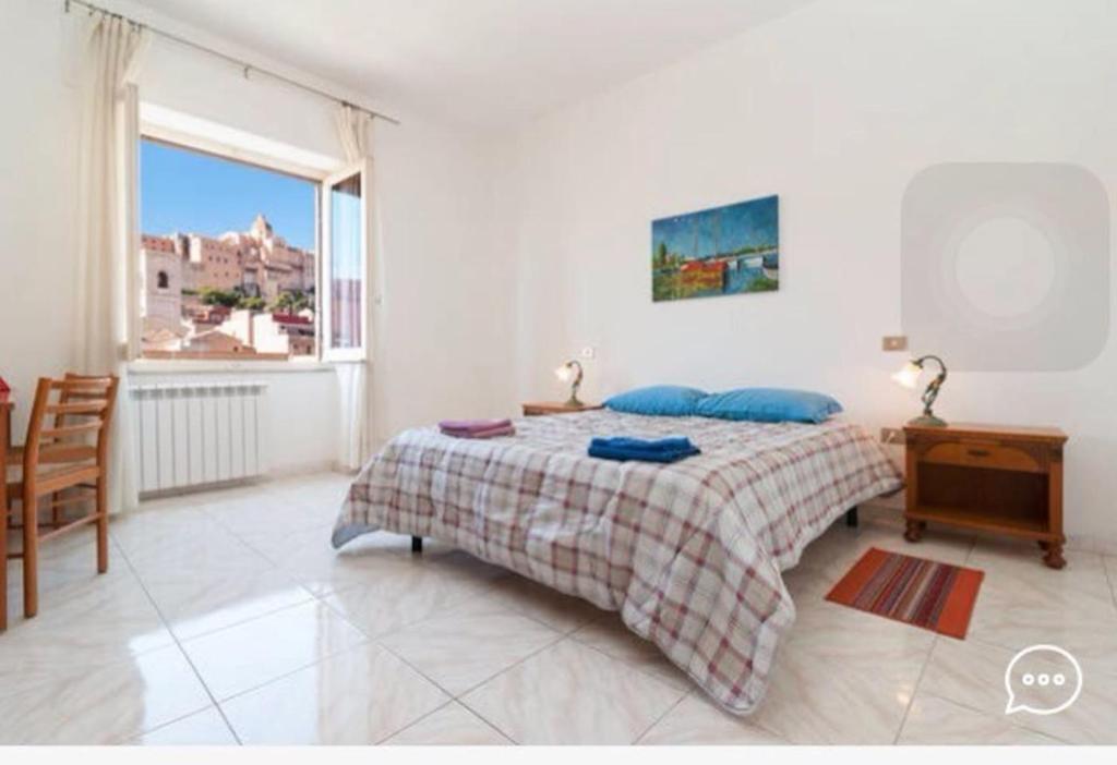 een slaapkamer met een bed, een tafel en een raam bij Molly & Luna in Cagliari