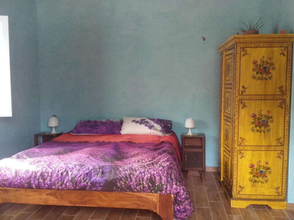 a bedroom with a bed and a yellow dresser at Rifugio Nel Bosco in Rieti