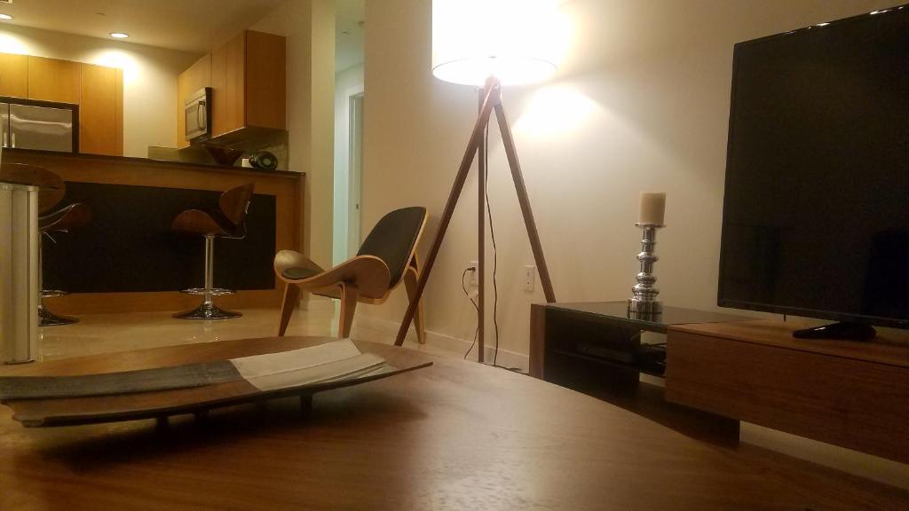 Hotel Brickell Deluxe Apartment with Free Parking, a living room with a television and a table with chairs at Brickell Deluxe Apartment with Free Parking in Miami