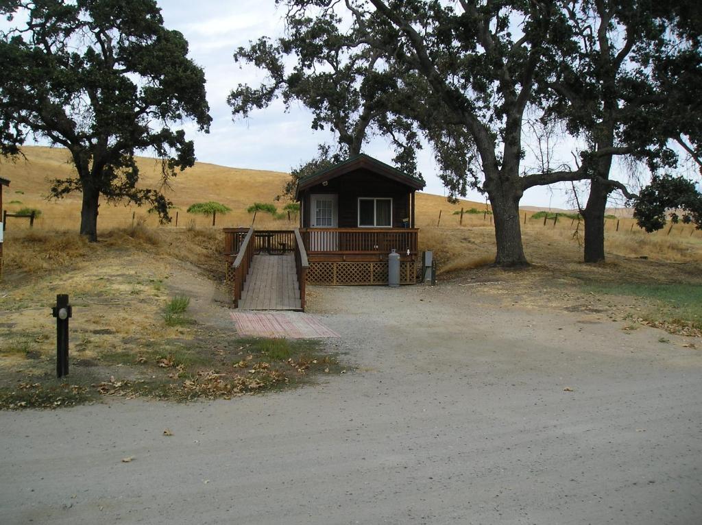 a small house in a field with trees at San Benito Camping Resort One-Bedroom Cabin 9 in Paicines