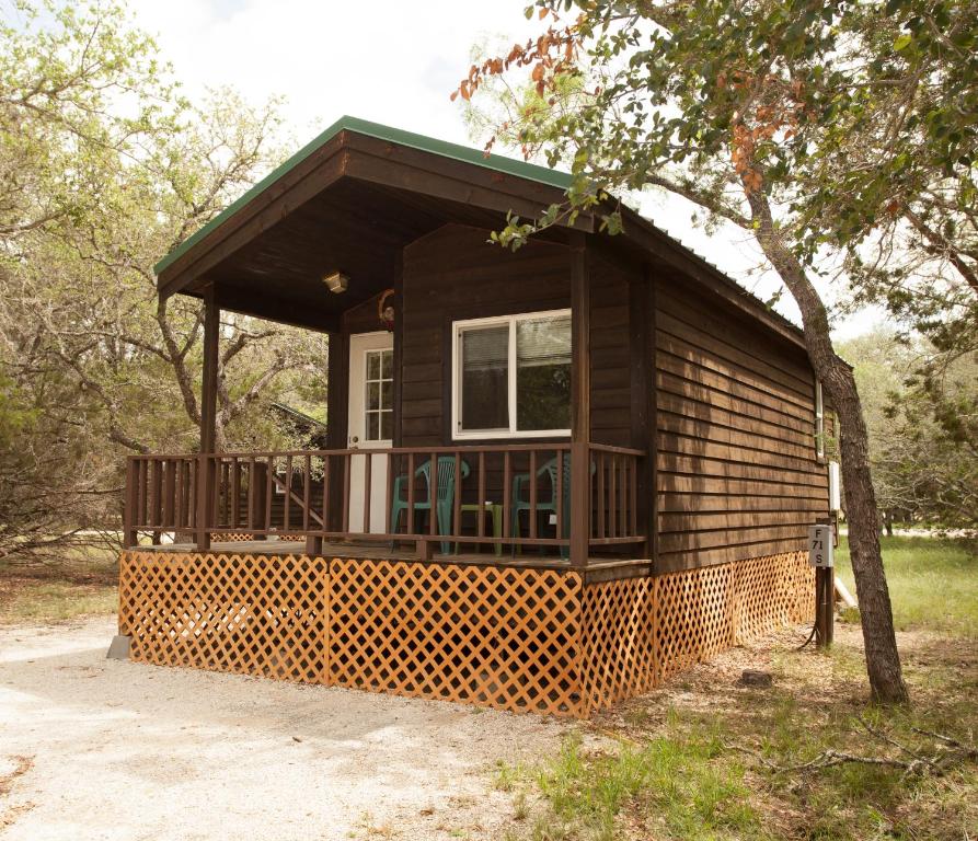 Cabaña pequeña con porche y árbol en Pio Pico Camping Resort Two-Bedroom Cabin 12, en Jamul