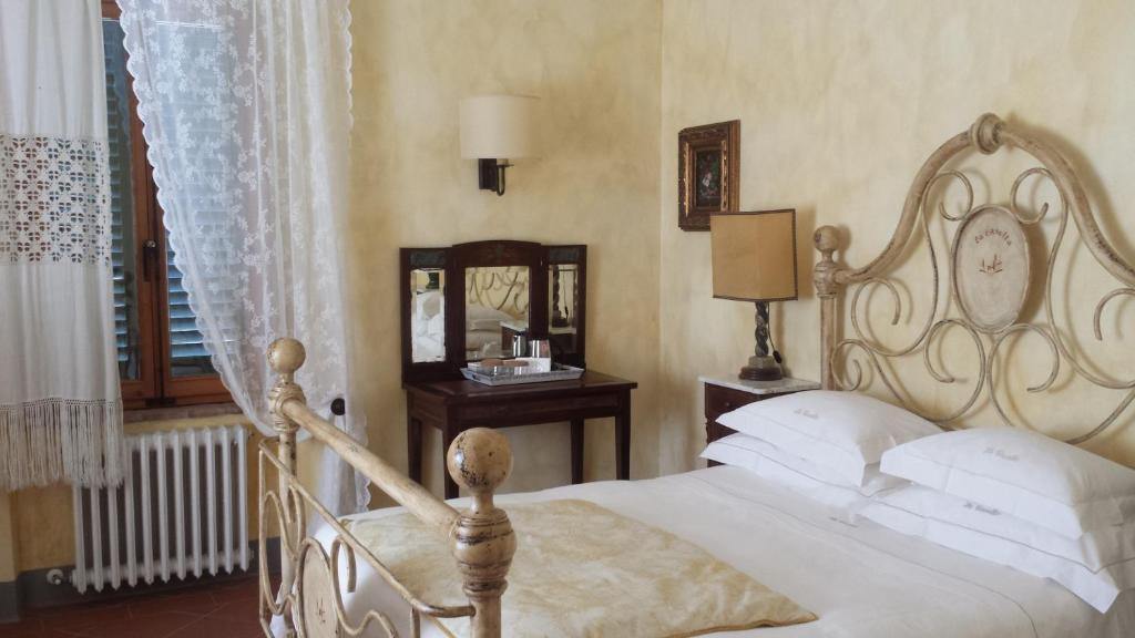 una camera con letto bianco e specchio di Agriturismo Borgo La Casetta a San Baronto