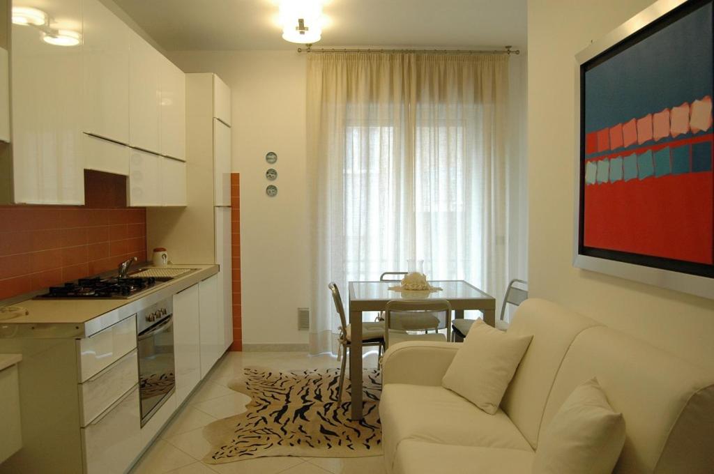 アラッシオにあるApartment Serenaのリビングルーム(ソファ付)、キッチン(テーブル付)