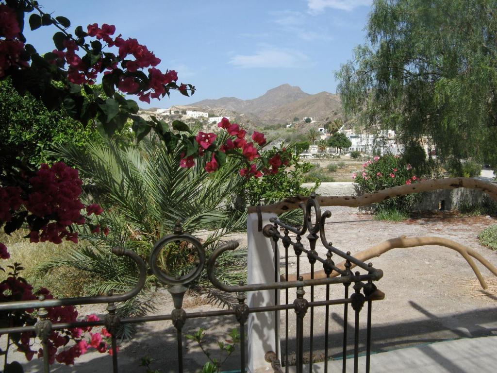 a garden with red flowers and a iron fence at Casalado in El Saltador Bajo