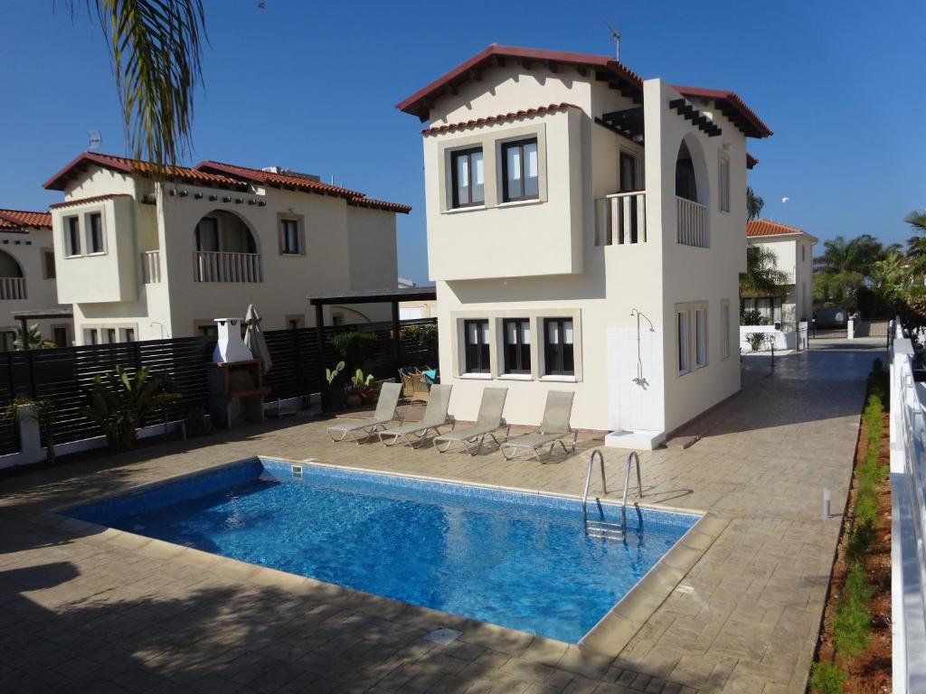 a house with a swimming pool in front of it at Cy-Blue in Protaras