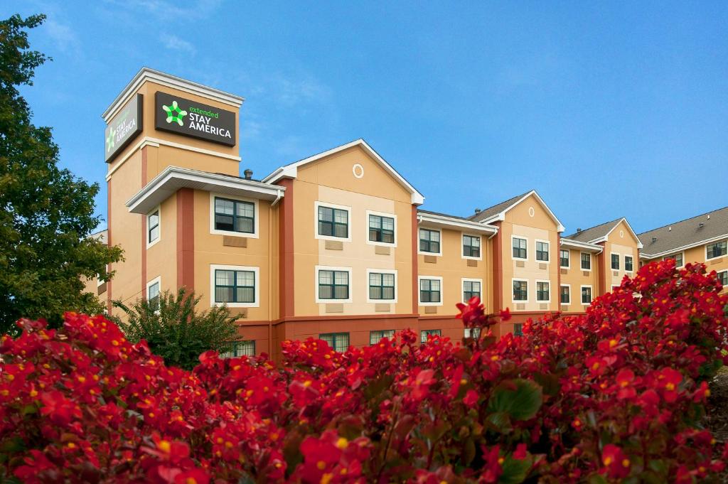 a hotel with red flowers in front of a building at Extended Stay America Suites - Columbia - Columbia Parkway in Columbia