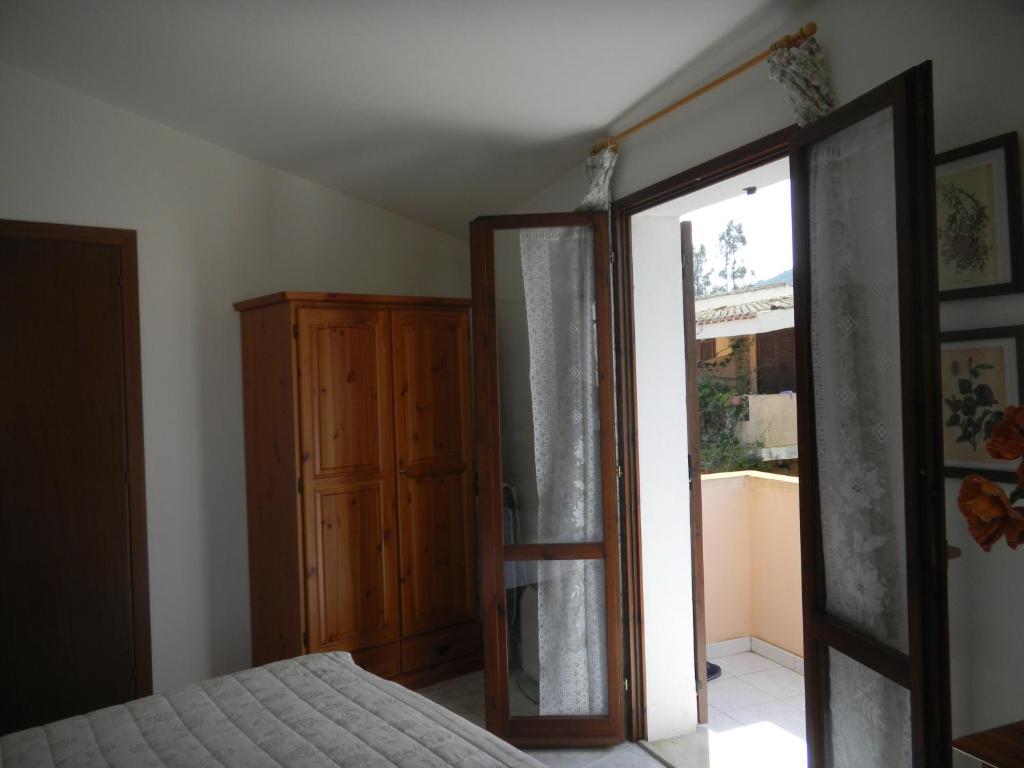 ヴィッラシミーウスにあるVilla Claudiaのベッドルーム1室(ベッド1台付)、スライド式ガラスドアが備わります。