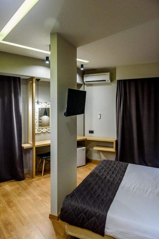 a bedroom with a bed and a desk at Agamemnon Hotel in Nafplio