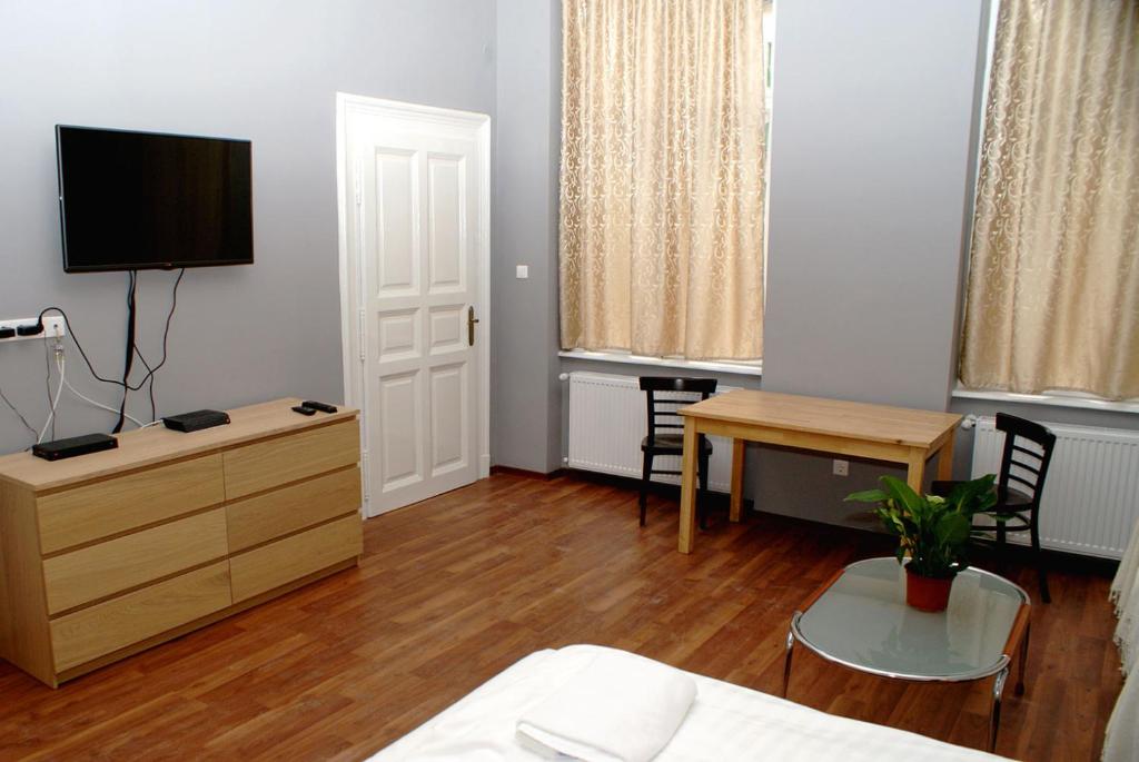 a room with a bed and a desk and a tv at Market Square Apartment in Budapest
