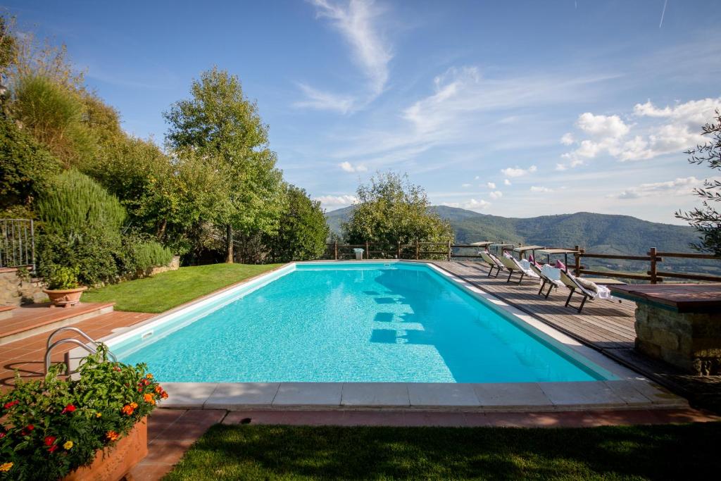 a swimming pool in a yard with mountains in the background at Villa La Foce in Castiglion Fiorentino