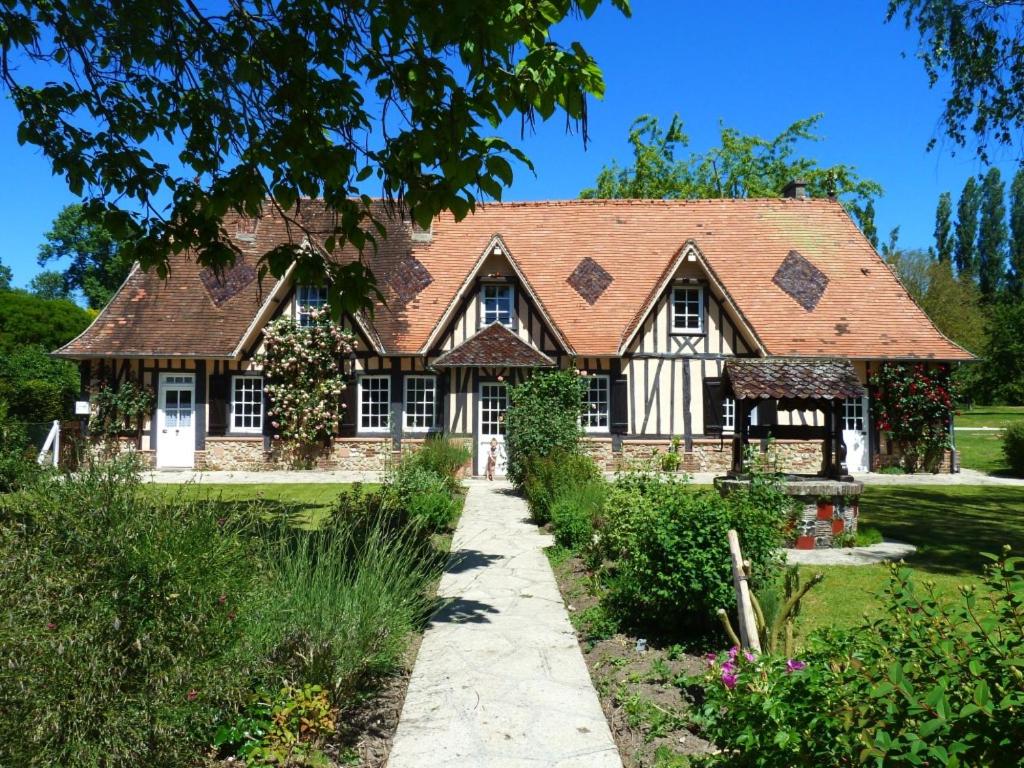 una casa con techo de gambrel y un camino en le clos Sainte Helene, en Glos-sur-Risle