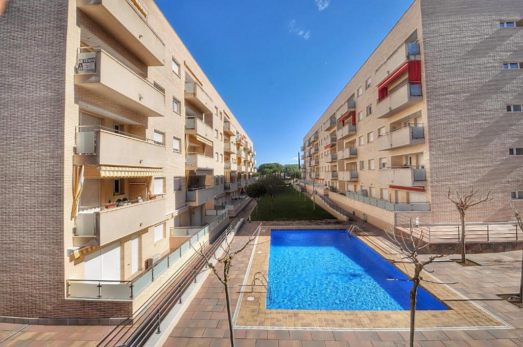 an apartment complex with a swimming pool between two buildings at Apartamento ADIA in Lloret de Mar