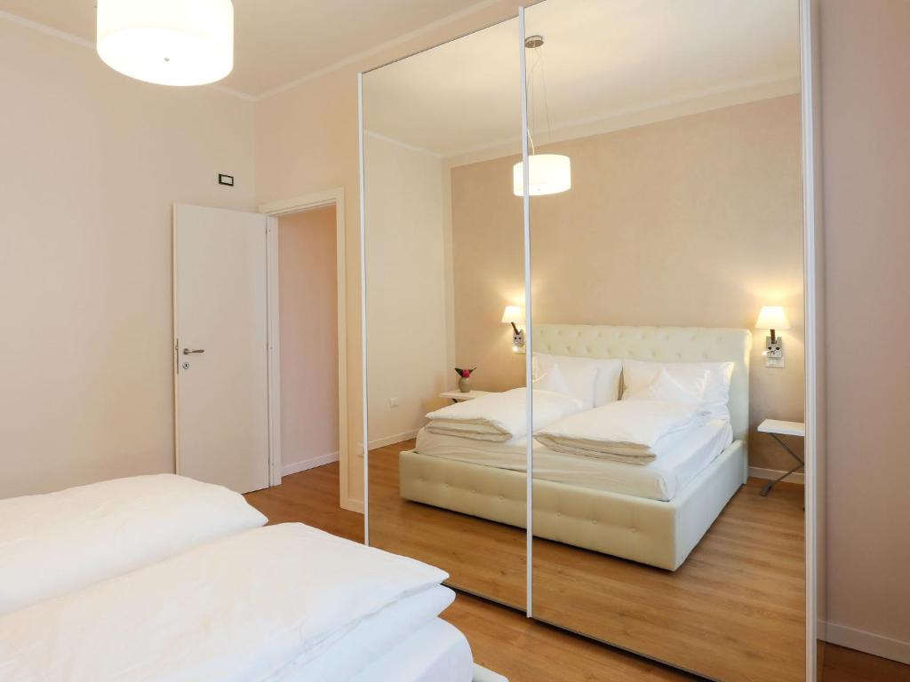 sypialnia z dwoma łóżkami i lustrem w obiekcie Les Suites w mieście Asola