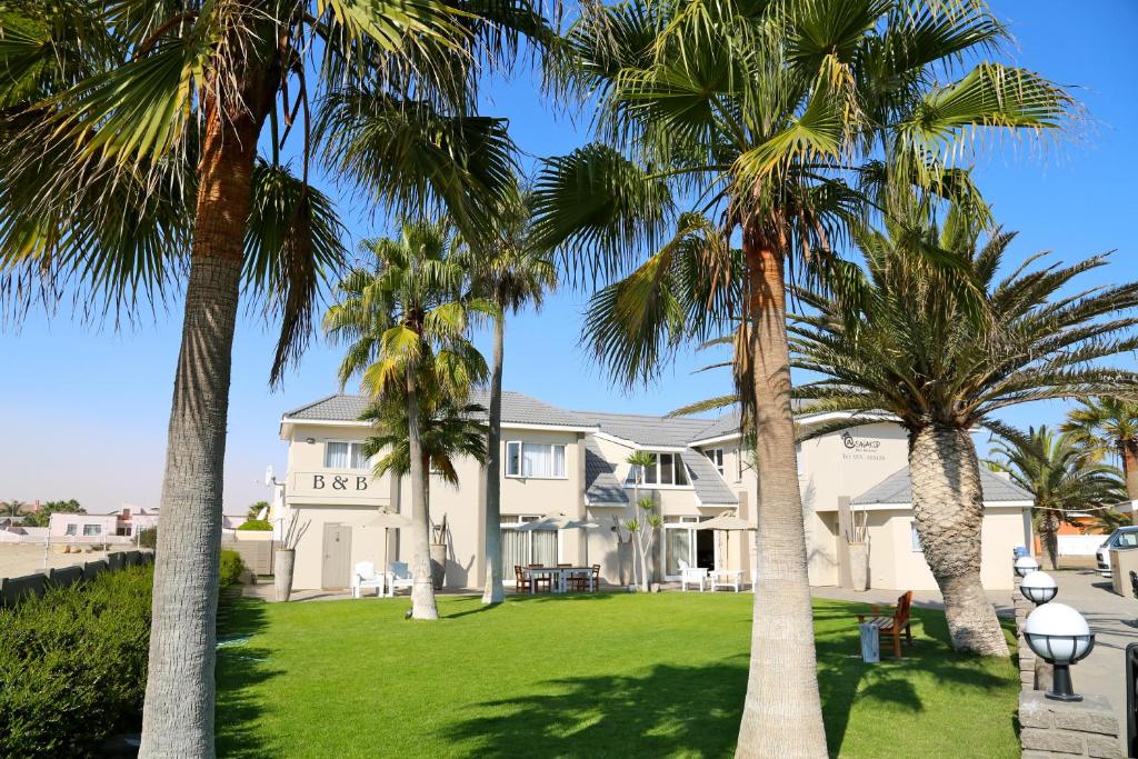 a house with palm trees in front of it at Stay @ Swakop in Swakopmund