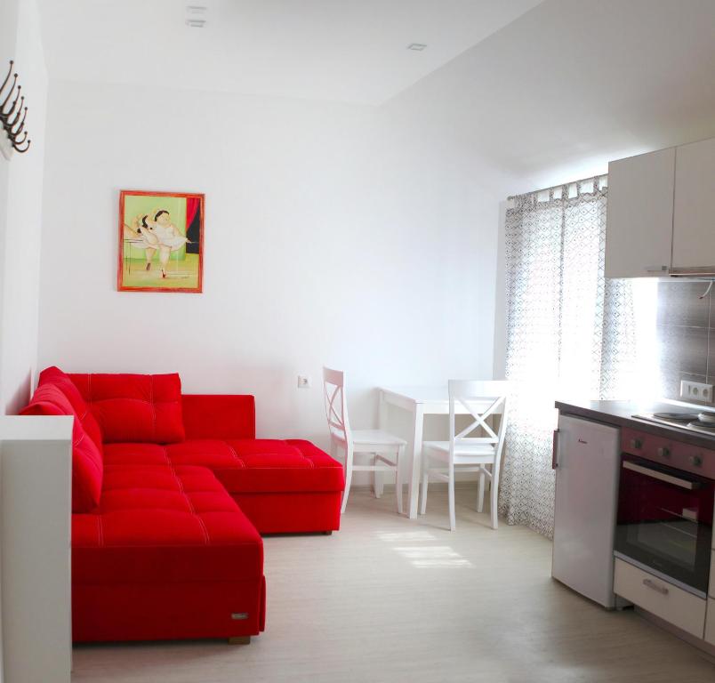 un soggiorno con un divano rosso e una cucina di Apartment Zolotoy Bereg 5 a Odessa