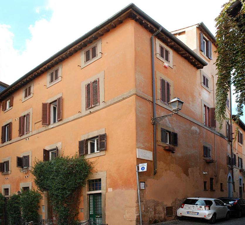 an orange building with cars parked in front of it at Casa delle Eroidi in Rome