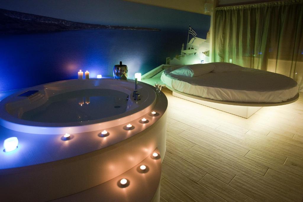 a bedroom with a tub with a bed and candles at Hotel Seven Rooms in Milan