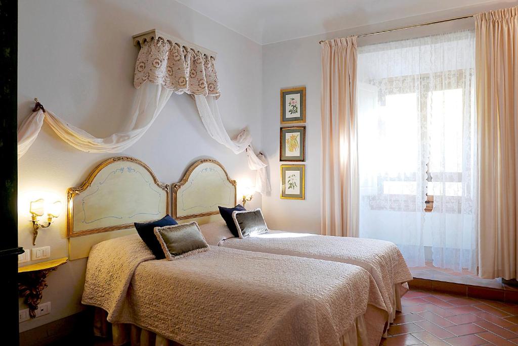 a bedroom with two beds and a window at Relais Cavalcanti Guest House in Florence
