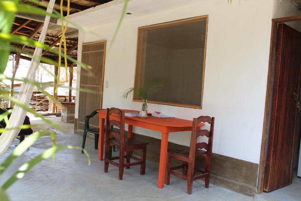 una mesa roja y sillas en una habitación en Casa Aquila Mazunte, en Mazunte