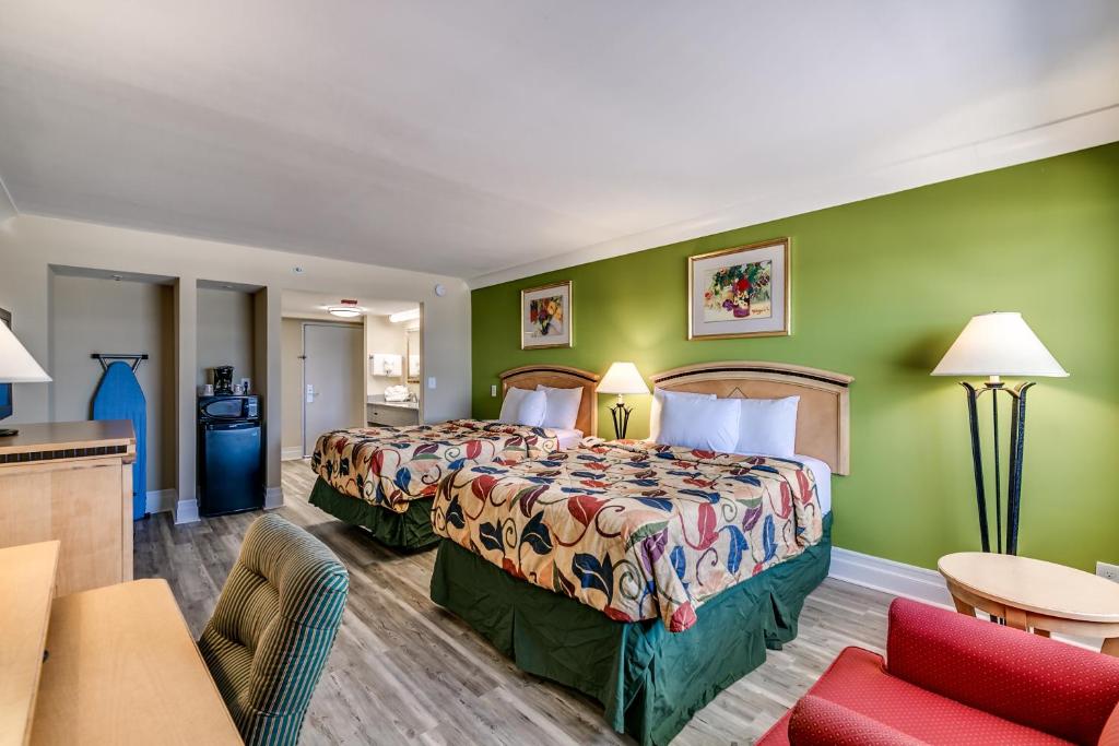 a hotel room with a bed and a living room at Beachcomber Inn & Suites in Myrtle Beach