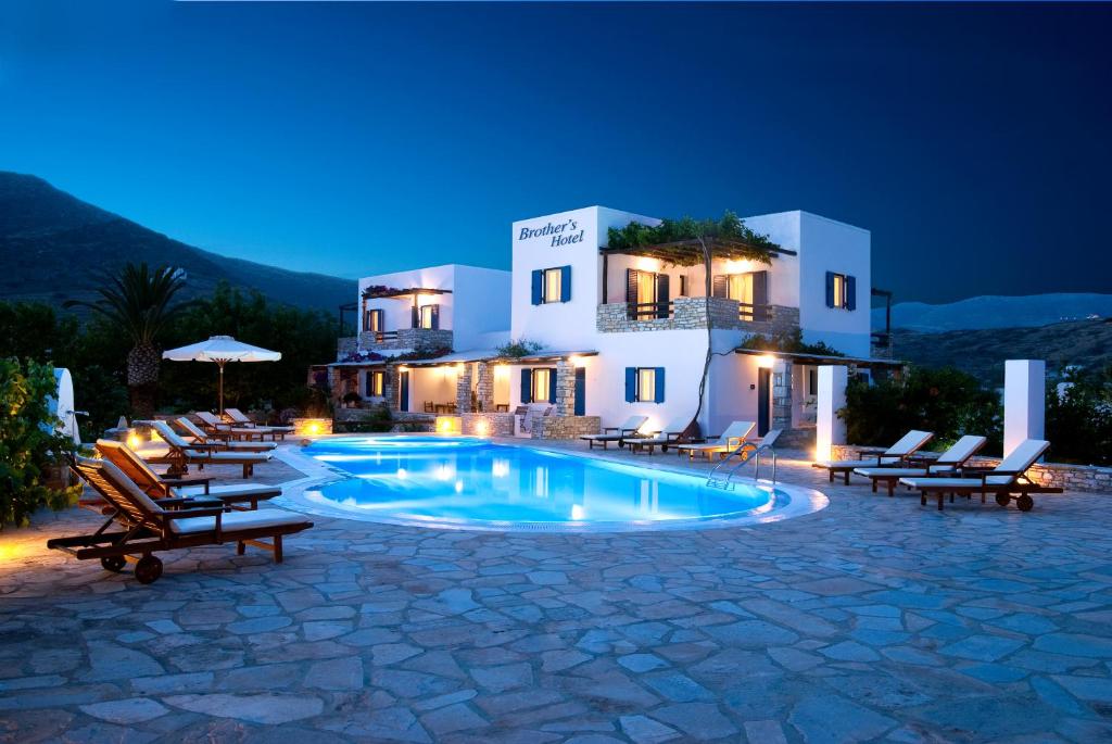 a resort with a pool and chairs and a building at Brother's Hotel in Ios Chora