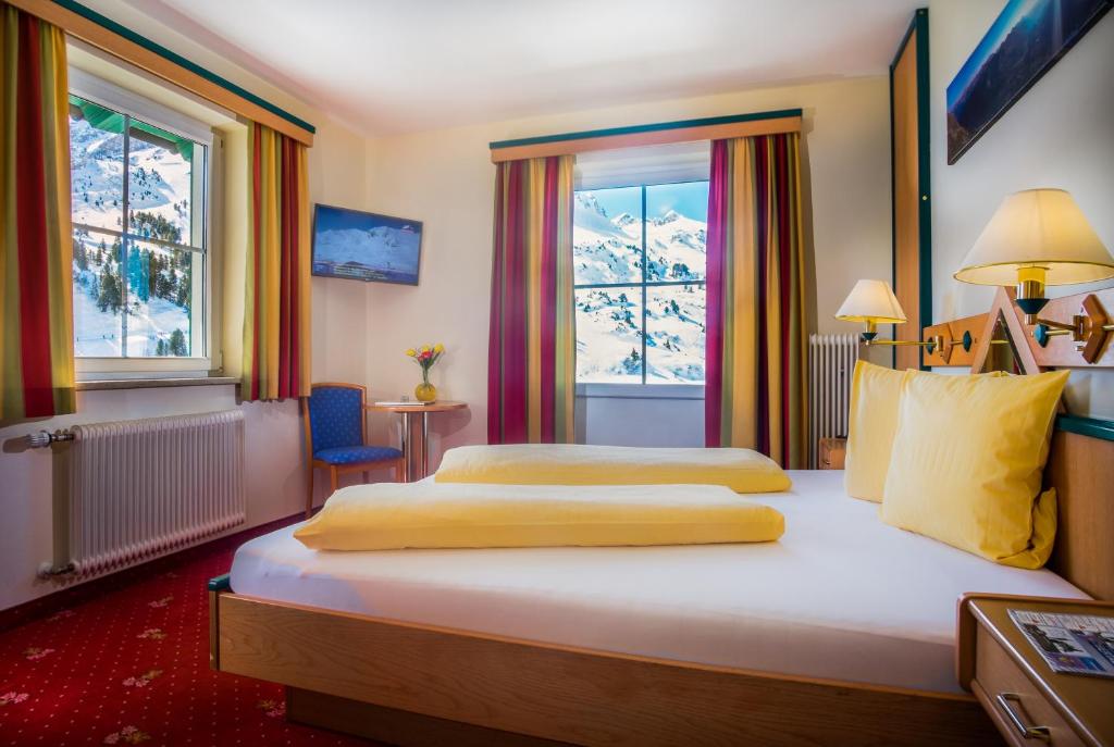 a hotel room with two beds and a window at Pension Weinberger in Obertauern