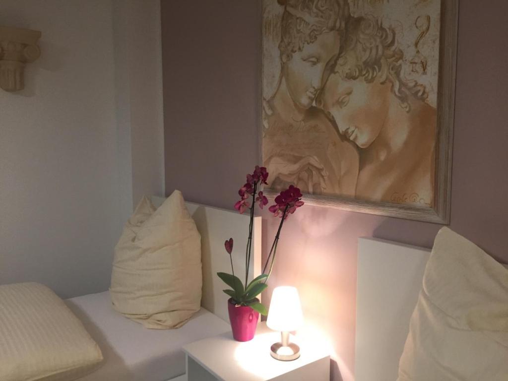 a bedroom with a couch and a painting on the wall at Apartment Ardi in Filderstadt