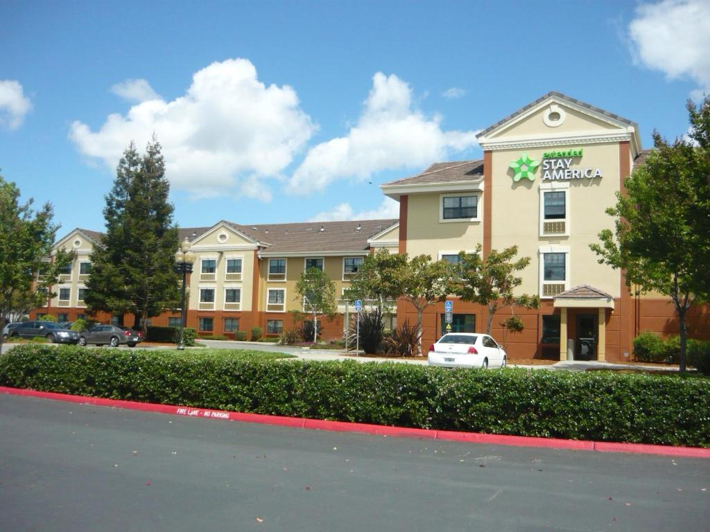 a large brick building with a clock on the front of it at Extended Stay America Suites - Pleasant Hill - Buskirk Ave in Pleasant Hill
