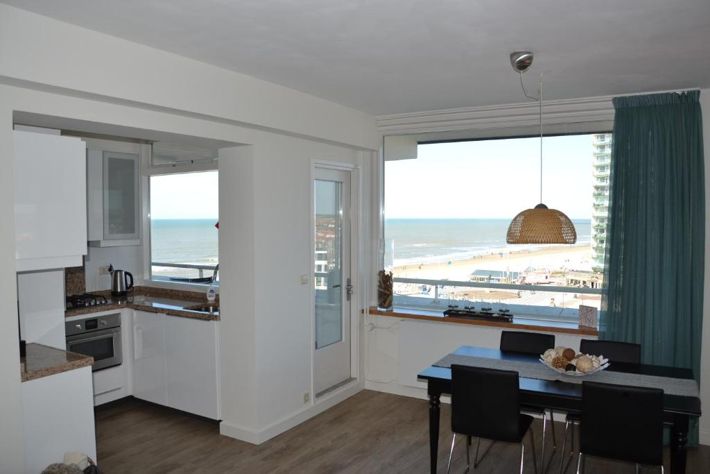 ザントフォールトにあるBeach Apartment Ikusasaのビーチの景色を望むキッチン&ダイニングルーム
