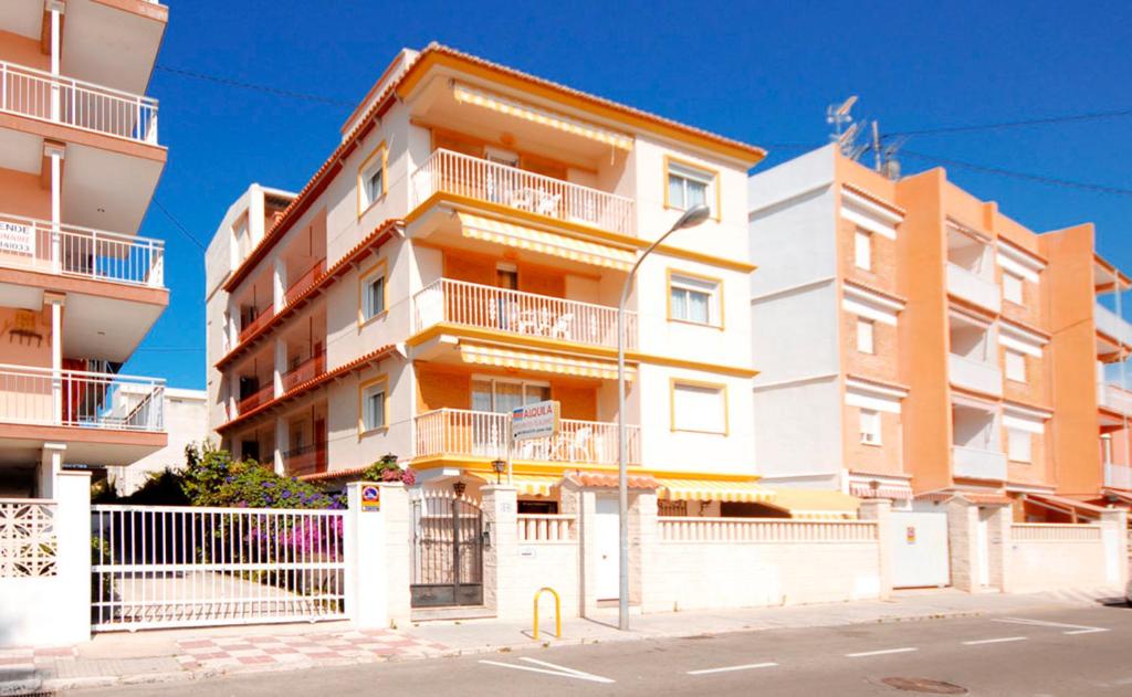 a tall apartment building with balconies on a street at Gandialco Gandia Playa in Gandía