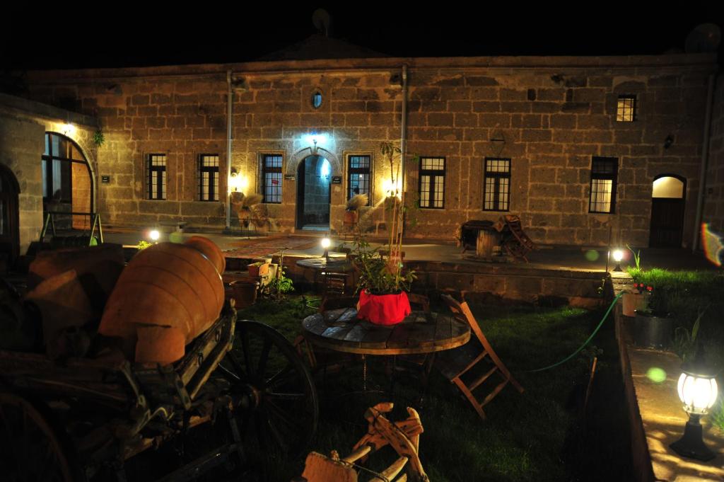 an old stone building with a table and chairs at night at Osmanoglu Hotel in Guzelyurt