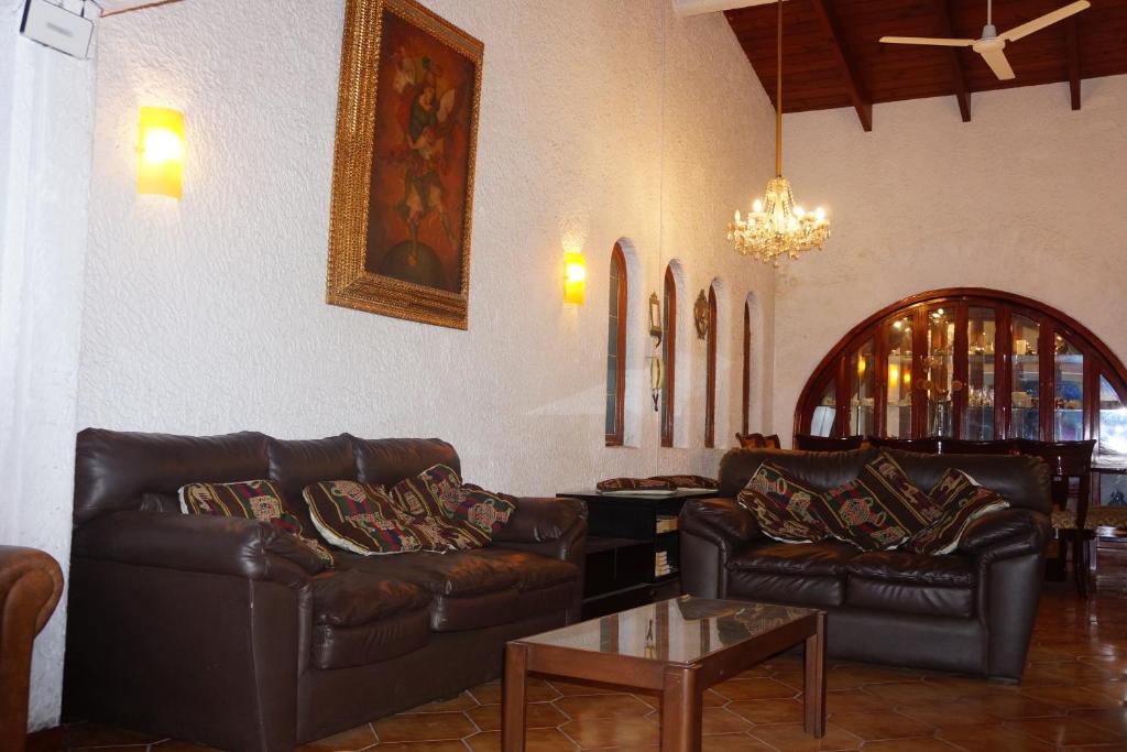 een woonkamer met leren banken en een tafel bij Family House in Lima