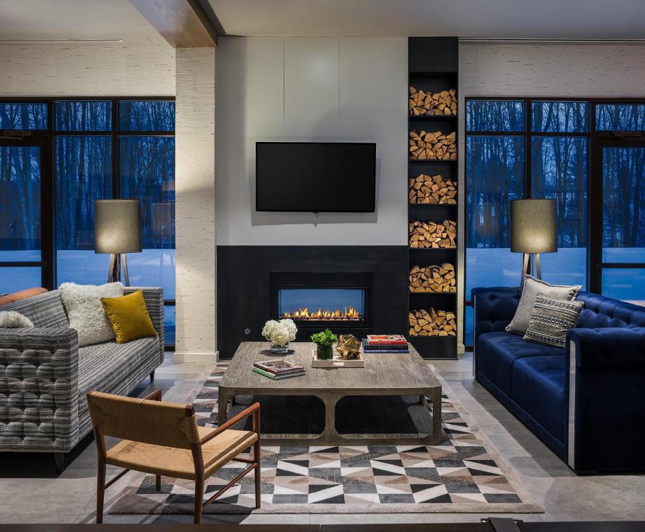 Hotel Zero Degrees Danbury في دانبري: غرفة معيشة مع أريكة ومدفأة