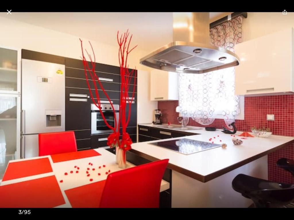 a kitchen with red chairs and a kitchen island with a stove at Artisti Elena in Paralia Katerinis