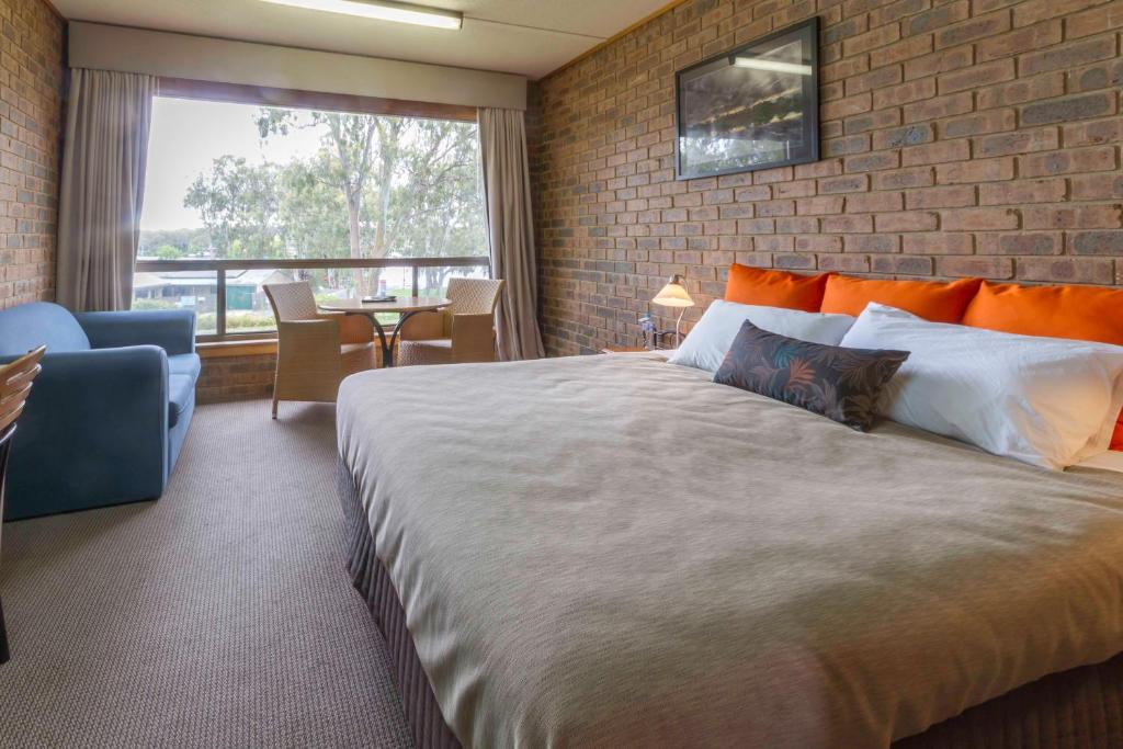 a bedroom with a large bed and a brick wall at Mannum Motel in Mannum