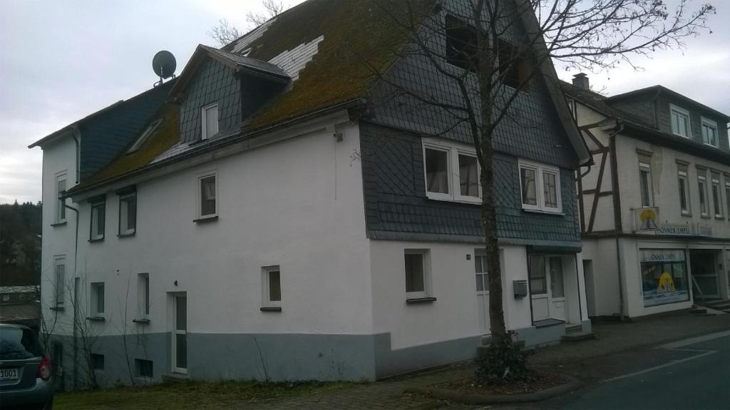 a white house with a black roof at Ferien-/Monteurwohnung Olbrich in Hilchenbach