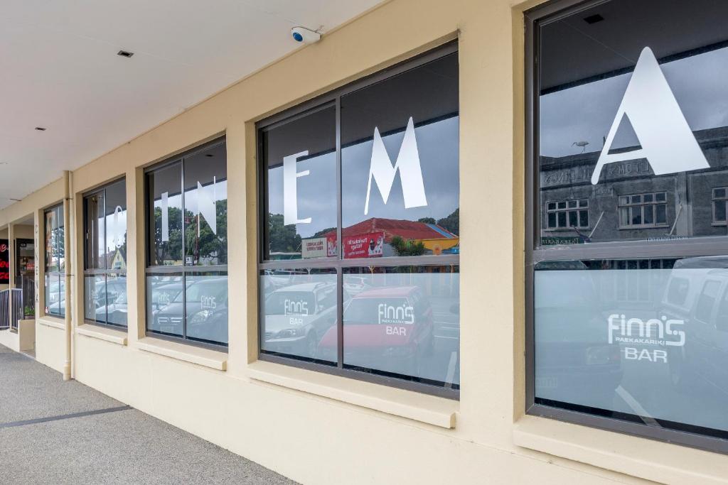 a row of windows on a building with m signs in the windows at Finns Paekakariki in Paekakariki