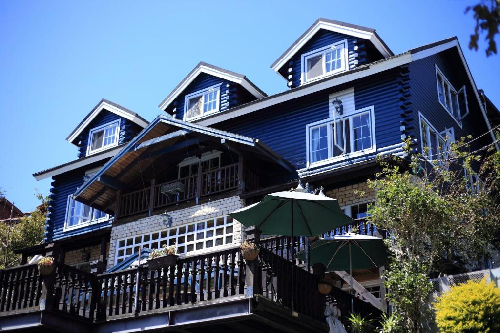 a blue house with an umbrella on a balcony at Cingjing Hanging Garden & Resort in Renai