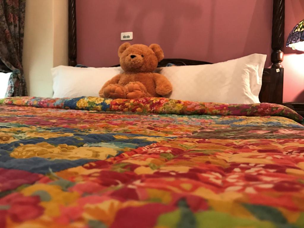 un osito de peluche sentado encima de una cama en Hualien Paris Home B&B, en Hualien City