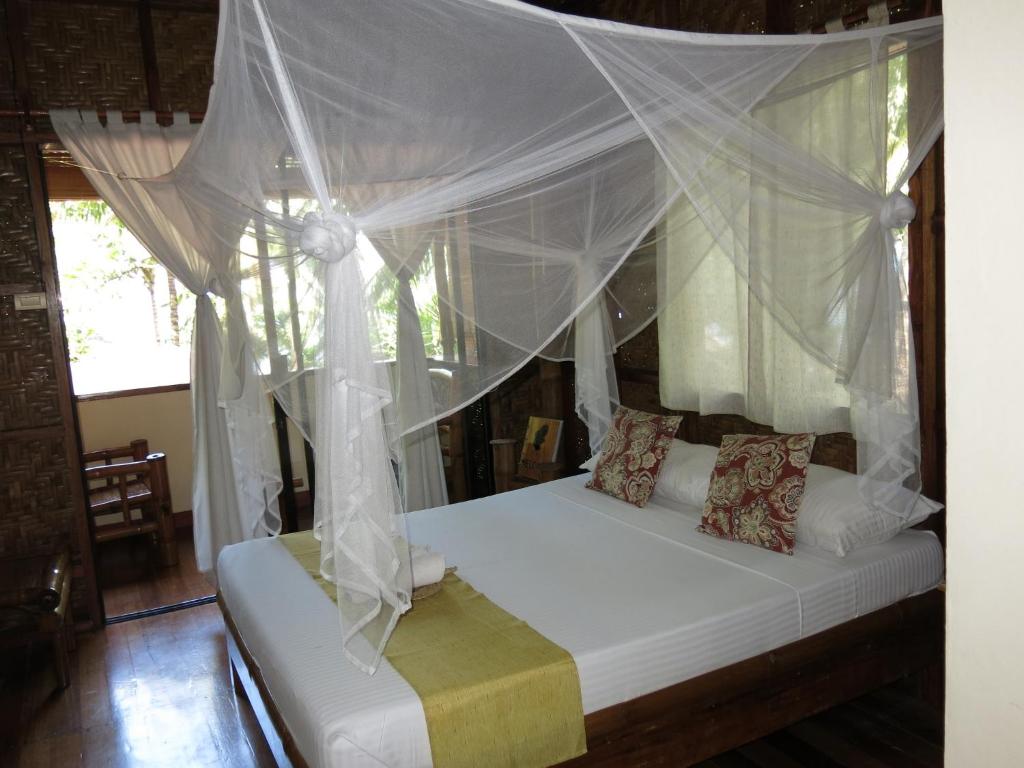 Postel nebo postele na pokoji v ubytování Camiguin Volcan Beach Eco Retreat & Dive Resort
