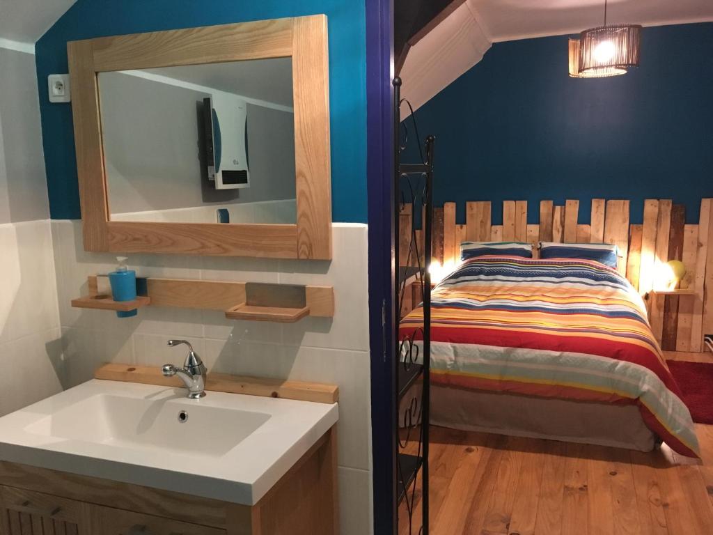 a bathroom with a sink and a bed at Le Moulin de Razou in Brassy