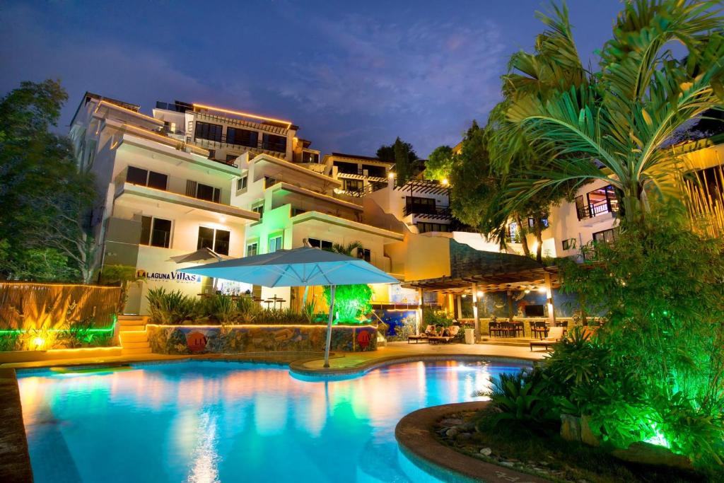 a hotel with a swimming pool in front of a building at Lalaguna Villas Luxury Dive Resort and Spa in Puerto Galera