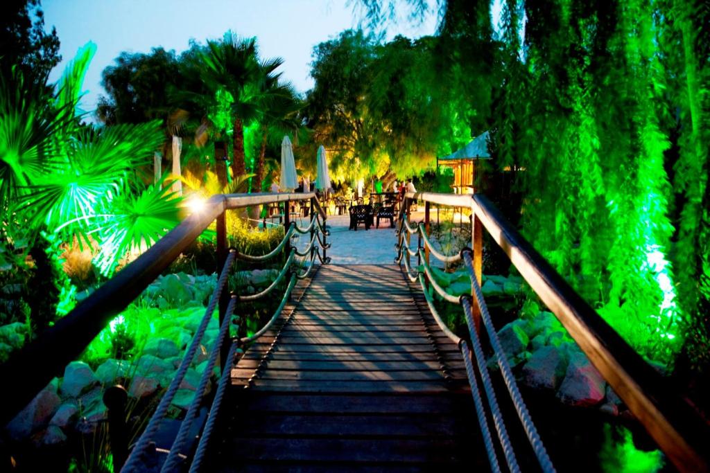 a bridge over a pond with green lights at Jardines de Casablanca in Caravaca de la Cruz