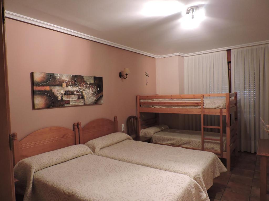 a bedroom with two beds and a bunk bed at Hostal Villa de Navarrete in Navarrete