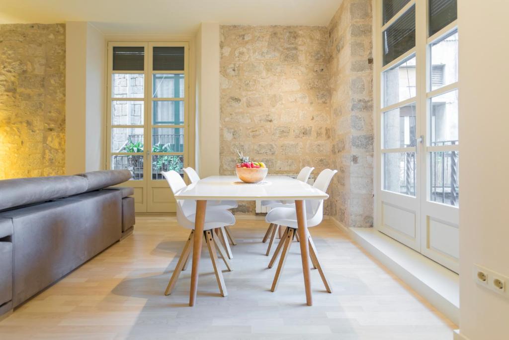 a dining room with a white table and white chairs at Bravissimo Cort Reial-1B in Girona