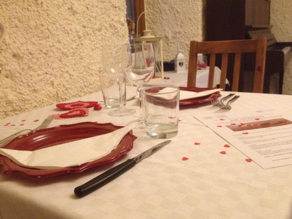 un tavolo con una tovaglia bianca e bicchieri da vino di La Tana del Ghiro a Porto Valtravaglia