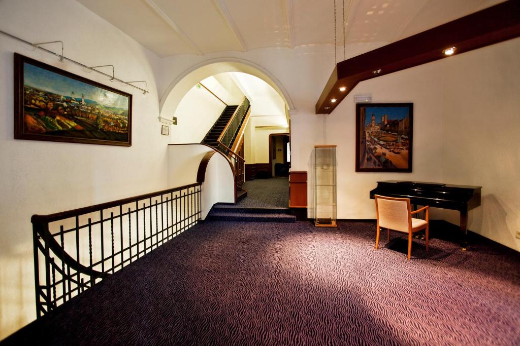 einen Flur mit einer Treppe und einem Klavier in einem Gebäude in der Unterkunft Hotel Arcade in Banská Bystrica