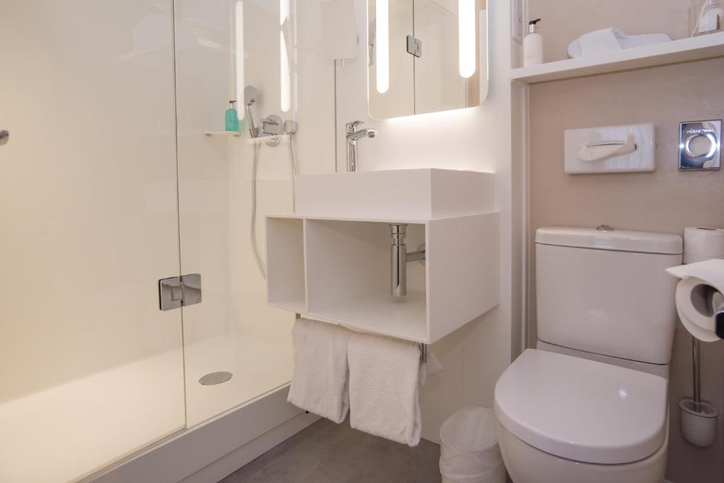 a bathroom with a toilet and a sink and a shower at Hotel America in Cannes